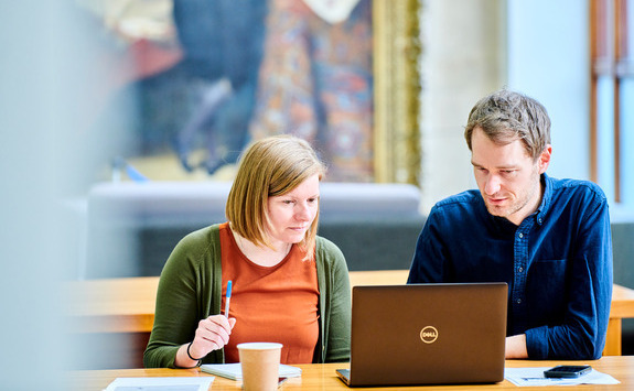 Two people looking at a laptop